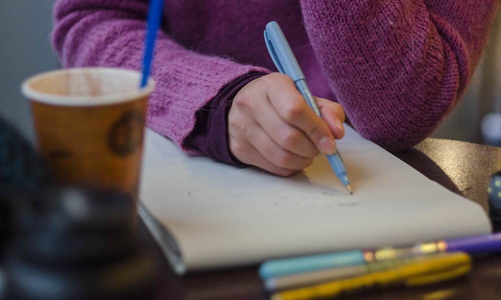 Mano apuntando en cuaderno