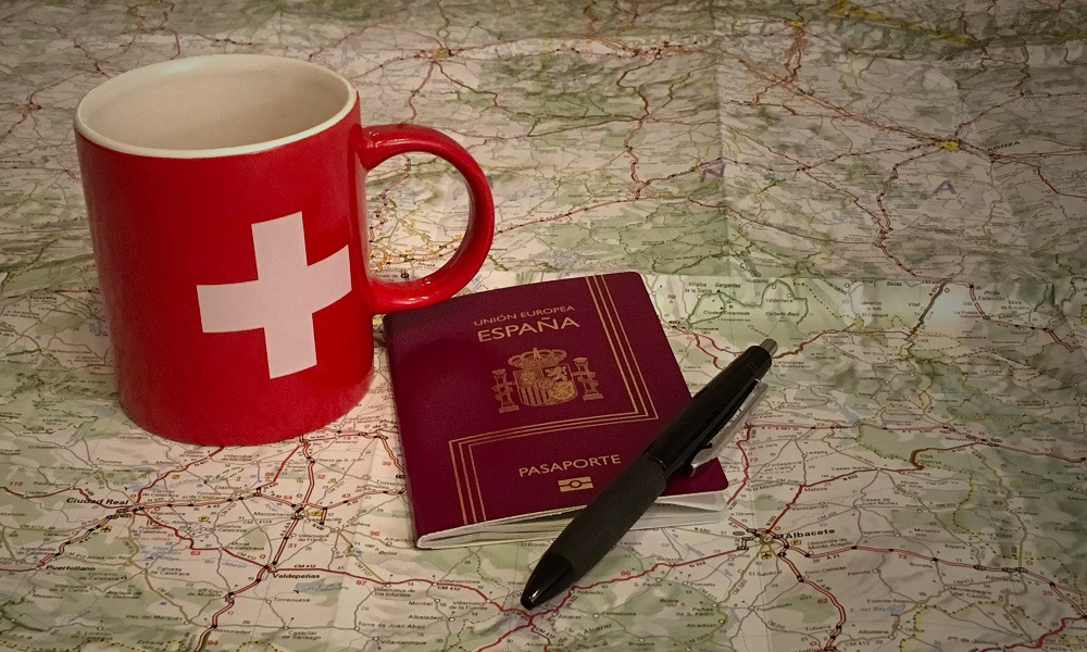 Taza de Suiza y pasaporte de España