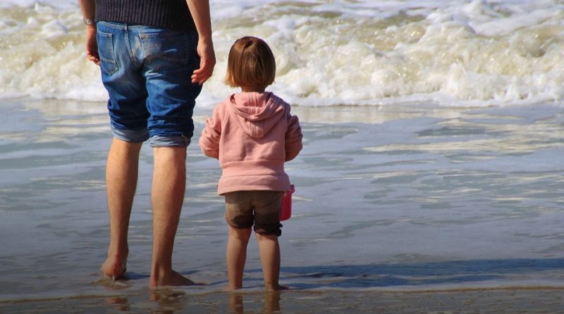 Niña en la playa con su padre